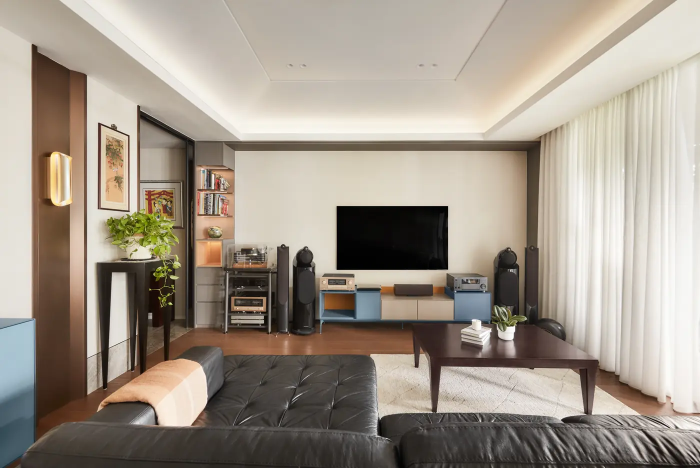Living room with blue-yellow TV console and leather sofa
