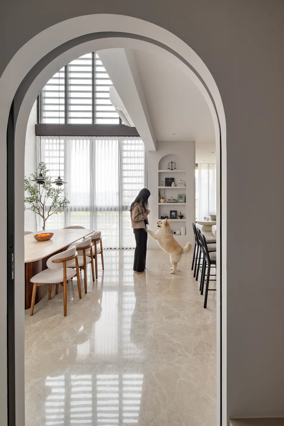 Arched doorway to the dining space with dog and bar counter visible