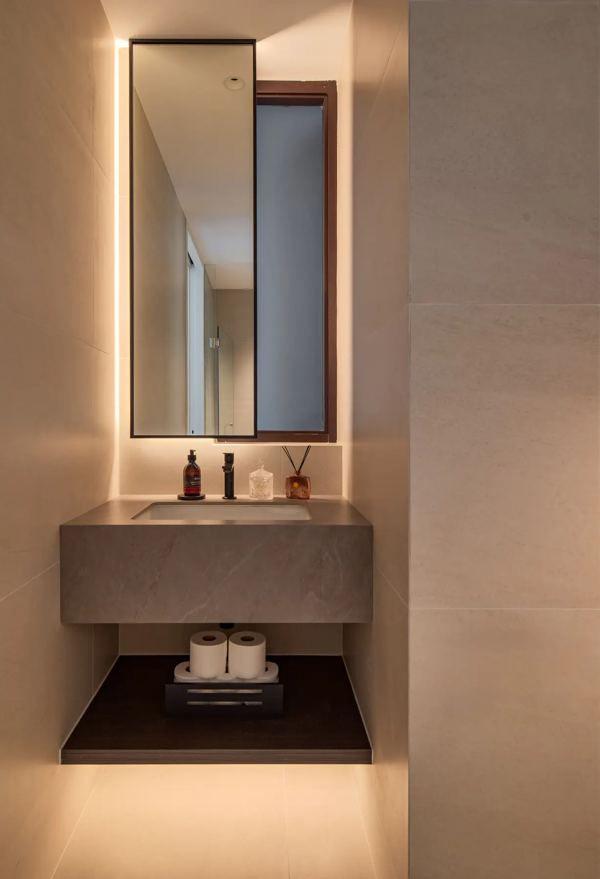 Bathroom vanity — warm backlit mirror, stone countertop and ceramic accessories