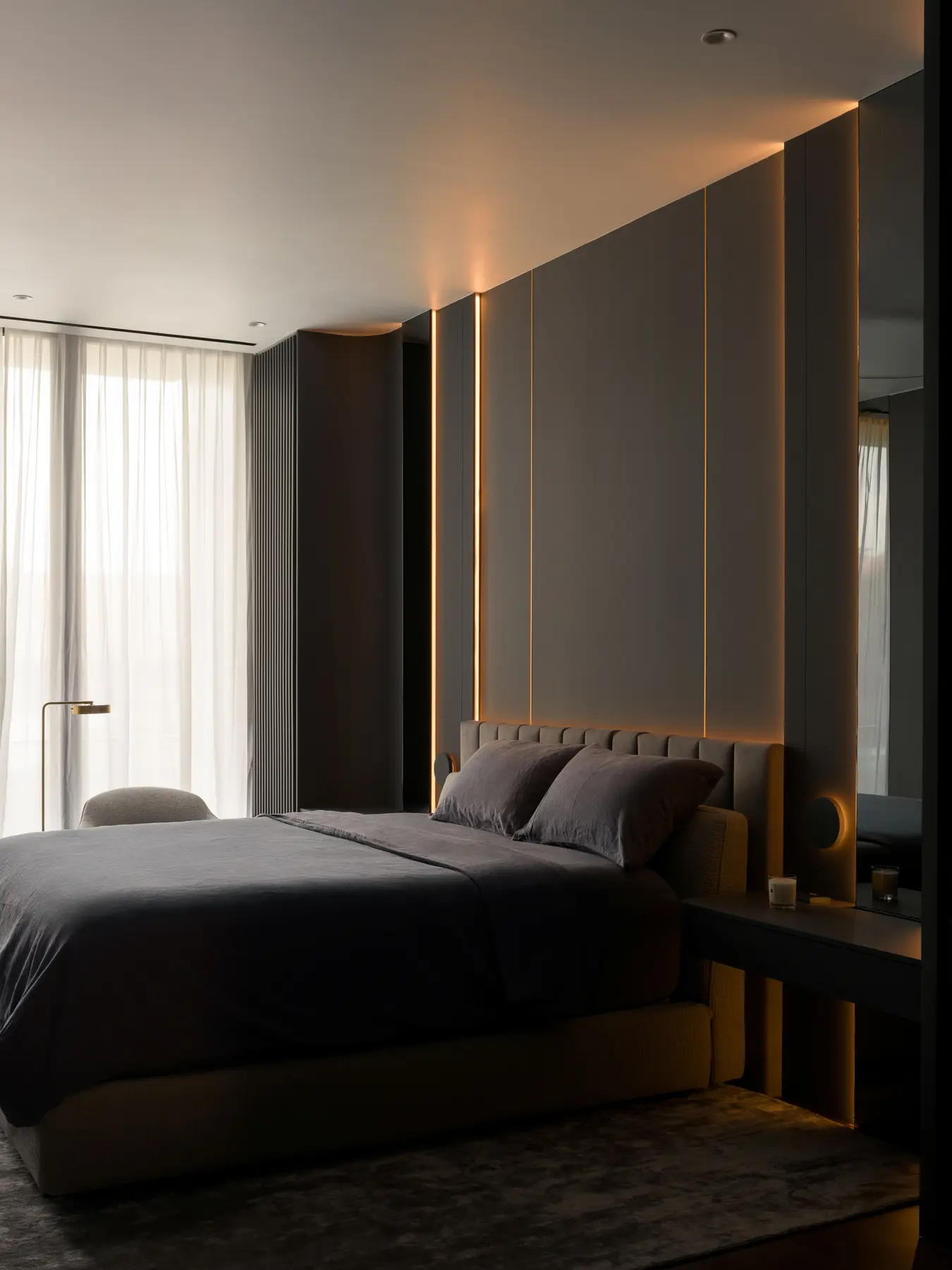 Master bedroom — evening mood with amber strip lighting glowing behind headboard panels