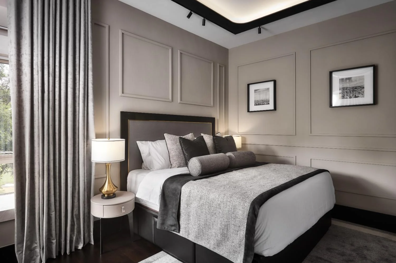 Master bedroom — bespoke headboard wall, upholstered armchair reading corner, layered lighting and curated art