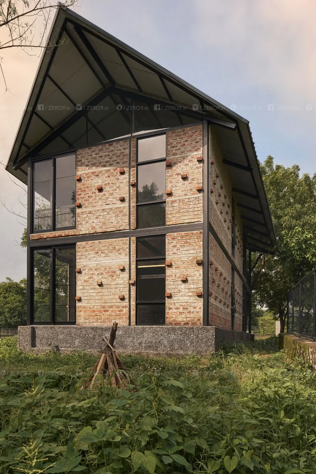 The gable elevation — exposed brickwork, steel framing and triangular glazing define the farmPAD facade